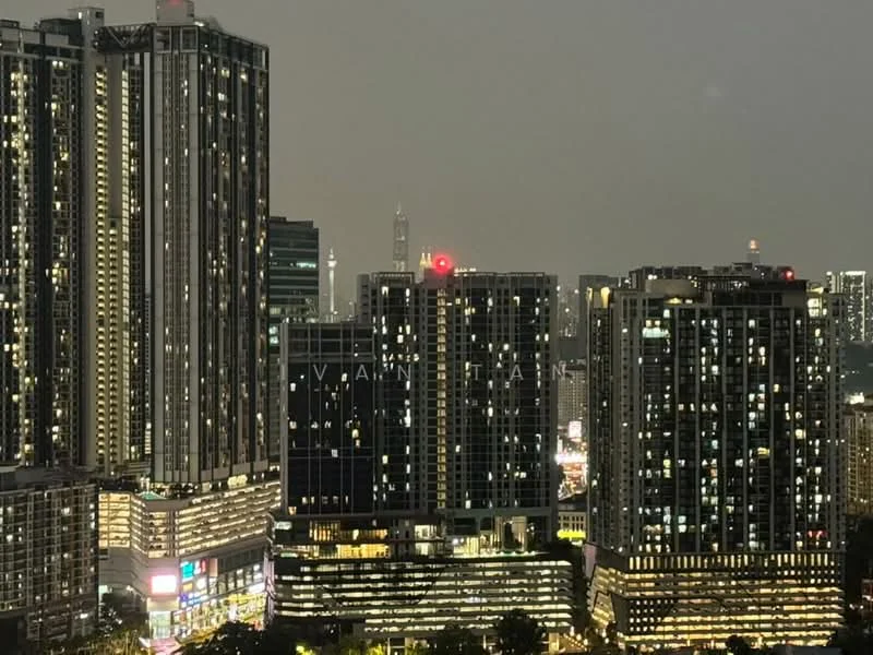 Exterior type: high-rise condominium; features: glass curtain wall, illuminated facade, surrounded by city skyline, multiple high-rise buildings, commercial space at ground level, night view, visible city lights; style: modern.