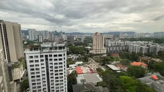 Exterior type: high-rise condominium; features: city skyline view, surrounded by greenery, multiple high-rise buildings, urban landscape, mixed-use development, residential and commercial buildings, open space, cloudy sky; style: modern.