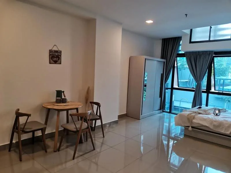 Room features: grey tiled flooring, white painted walls, large window with sheer curtains, sliding glass door, round wooden dining table, 2 wooden chairs, built-in wardrobe, bed with white bedding, decorative wall sign, potted plant, kettle on table; style: modern; view: garden.