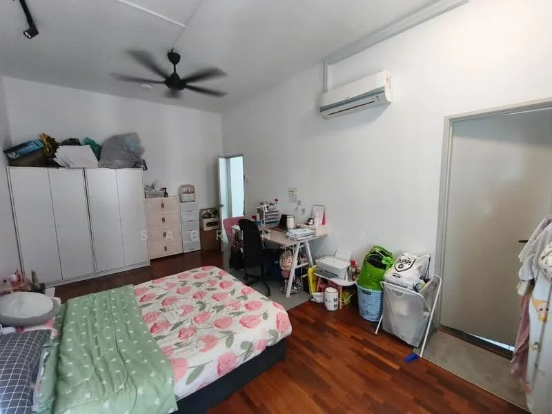 Bedroom features: queen-size bed with floral bedding, wooden flooring, white painted walls, 5-blade ceiling fan, wall-mounted split AC, built-in wardrobe with sliding doors, study desk with chair, full-length mirror, door leading to hallway, laundry basket, plastic storage bins.