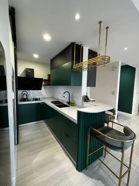 Kitchen features: green cabinetry, black upper cabinets, white quartz countertop, single-bowl stainless-steel sink, chrome pull-down faucet, built-in gas hob, black range hood, pendant light fixture, bar stools, recessed downlights, wood-look laminate flooring, wall-mounted phone, decorative plants; style: modern.