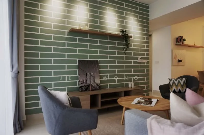 Living features: green accent wall with white brick pattern, light wood TV console, round wooden coffee table, grey fabric armchairs, pink and white patterned cushion, decorative wall shelf, framed artwork, houseplant on wall shelf, recessed lighting, curtains, neutral wall color; style: modern.