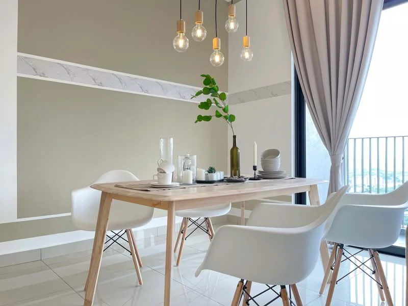 Dining features: wood dining table, 4 white plastic dining chairs, hanging pendant lights with exposed bulbs, green accent wall, white marble strip on wall, large glass sliding door, curtains, ceramic tile flooring, decorative plant on table, glass vase, white plates, cutlery, water carafe; style: modern; view: city.
