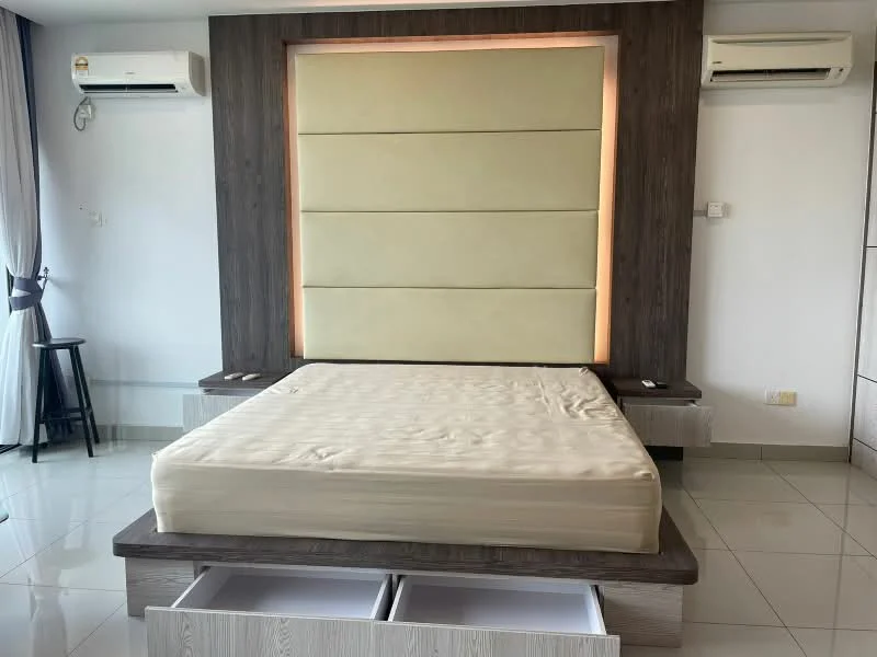 Bedroom features: queen-size bed base without mattress, upholstered headboard with soft panels, built-in storage drawers under bed, white glossy cabinetry, wall-mounted air conditioning unit, large window with sheer curtains, ceramic tile flooring, recessed lighting, neutral wall color; style: modern.