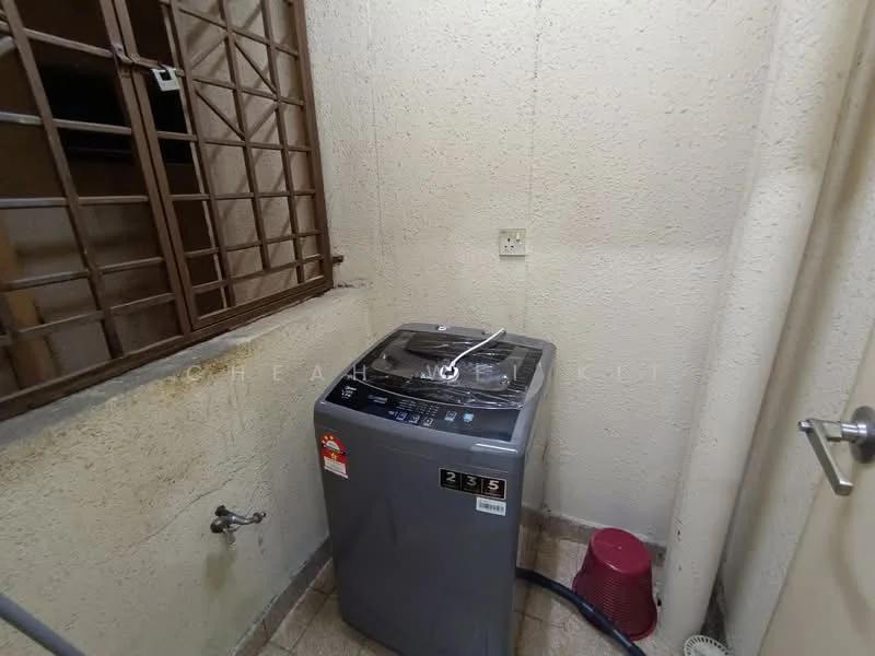 Laundry features: top-load washing machine, grey exterior of washing machine, water inlet connection, drainage outlet, cream painted walls, tile flooring, window with metal grille, pink bucket.