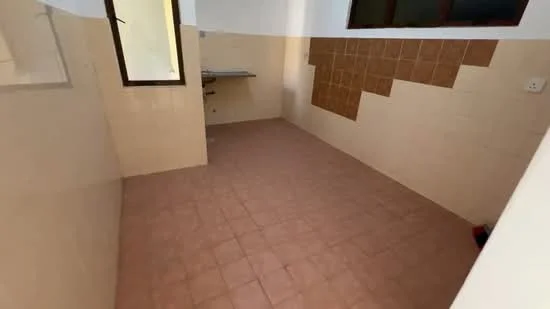 Room features: tile flooring, cream painted walls, brown tiled wall, single window, kitchen countertop, sink area, empty space, corner layout.