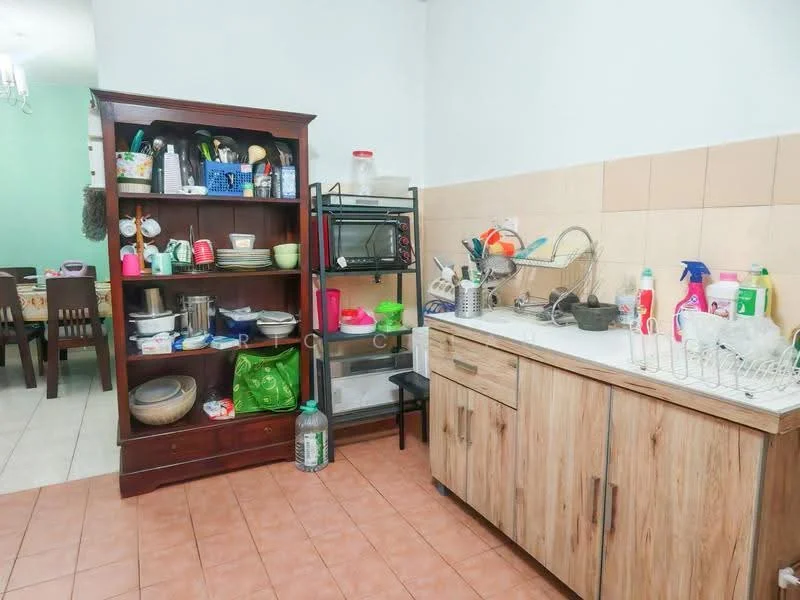 Kitchen features: wooden cabinetry, white countertop, stainless-steel sink, chrome faucet, ceramic tile backsplash, open shelving, microwave, various kitchen utensils, plastic storage containers, cleaning supplies, dining plates, cooking pots, bowl, dish rack.