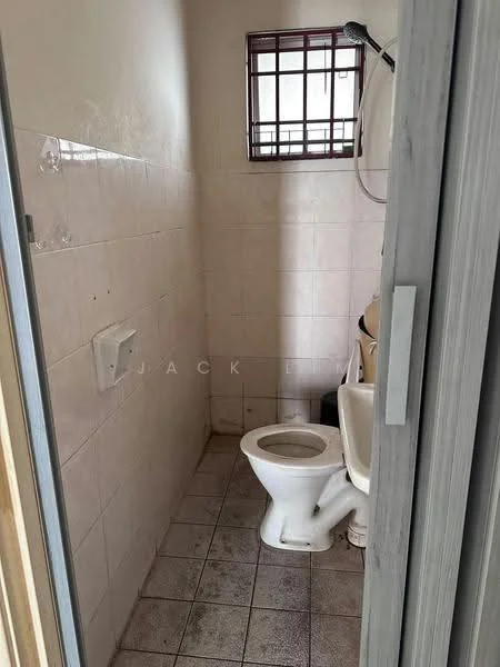 Bathroom features: white toilet, shower head, tile flooring, white tiled walls, window with metal grille, toilet paper holder, small shelf, sink, mirror.