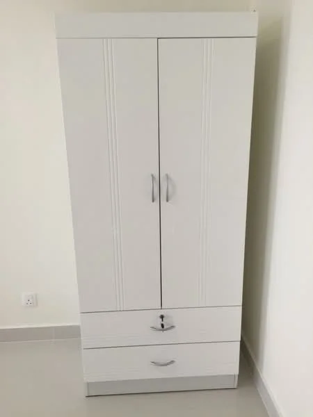 Room features: white wardrobe with two doors, two drawers at the bottom, metal handles, plain surface, minimalist design, tiled flooring, neutral wall color; style: modern.