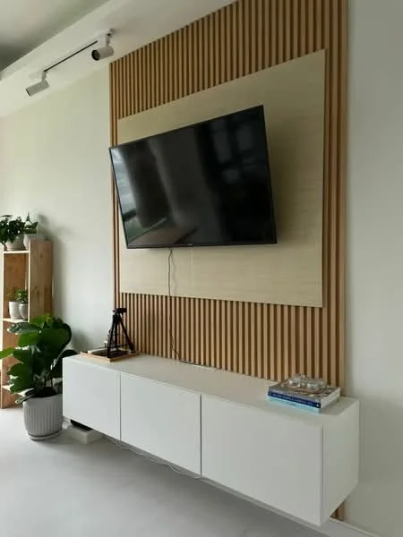 Living features: wall-mounted TV, white media console, wood panel accent wall, green houseplants in ceramic pots, decorative items on console, light-colored flooring, recessed lighting, minimalist decor; style: modern.
