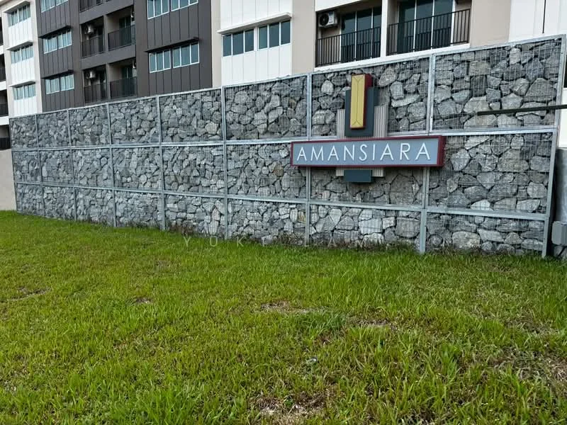 Exterior type: low-rise apartment block; features: stone cladding fence, landscaped grass area, signage with the name 'AMANSIARA', metal frame structure, modern design elements; style: modern.
