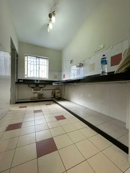 Kitchen features: white painted walls, tile flooring with red and cream squares, single-bowl stainless-steel sink, chrome faucet, black countertop, window with metal bars, overhead lighting, built-in cabinetry, open shelving, stool for seating.