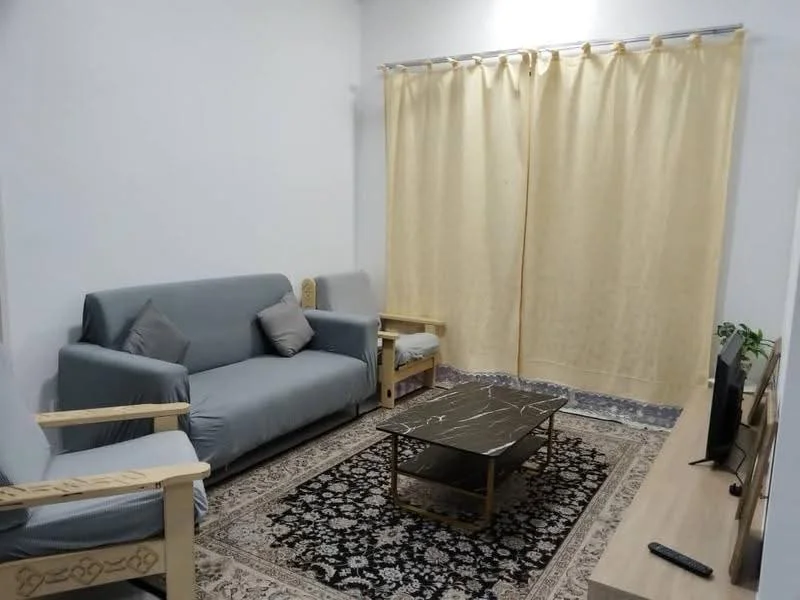 Living features: 3-seater fabric sofa in grey, 2 armchairs with wooden frames, coffee table with marble top, TV console, wall-mounted TV, area rug with intricate pattern, curtains in light yellow, decorative plant in ceramic pot, light-colored walls, wooden flooring; style: modern.