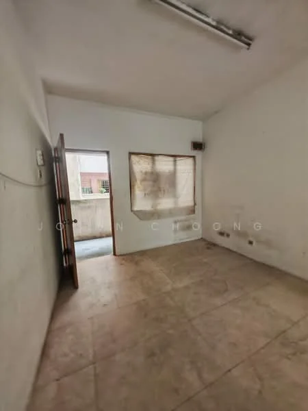 Room features: plain white walls, tile flooring, single door, window with sheer curtain, exposed ceiling with fluorescent lights, empty room.