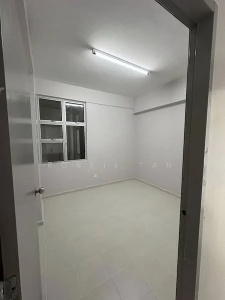 Room features: white painted walls, tile flooring, fluorescent ceiling light, window with multiple panes, neutral color scheme, empty space, no visible furniture, single door entry; style: minimalist.