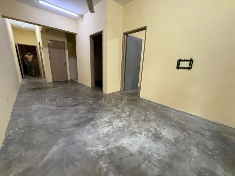 Room features: concrete flooring, yellow painted walls, plain ceiling, doorway openings, no visible lighting fixtures, narrow hallway layout; style: minimalist.