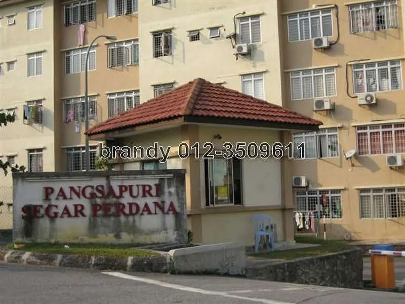 Exterior type: low-rise apartment block; features: cream painted facade, red pitched tile roof, multiple air conditioning units on facade, signage with name 'Pangsapuri Segar Perdana', surrounding pavement, entrance gate, landscaped area in front; style: modern.