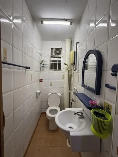 Bathroom features: white tiled walls, brown tiled flooring, one-piece toilet, single-sink vanity with wall-mounted mirror, chrome basin mixer faucet, shower with wall-mounted showerhead, toilet paper holder, towel rack, shelf for toiletries, window for natural light, light fixture on ceiling.