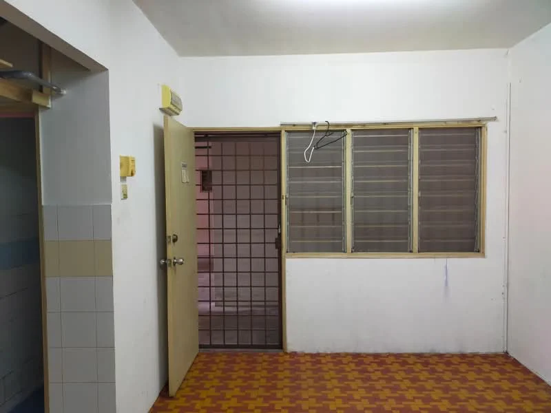 Room features: white painted walls, brown tiled flooring, single door, grilled window, window with metal bars, ceiling light fixture.