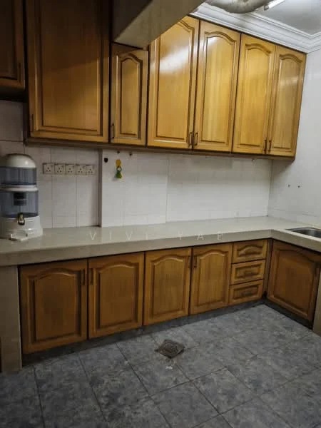 Kitchen features: wooden cabinetry with brown finish, white tiled backsplash, grey tiled flooring, single-bowl stainless-steel sink, countertop with light colour, water dispenser, multiple upper cabinets, lower cabinets with drawers.