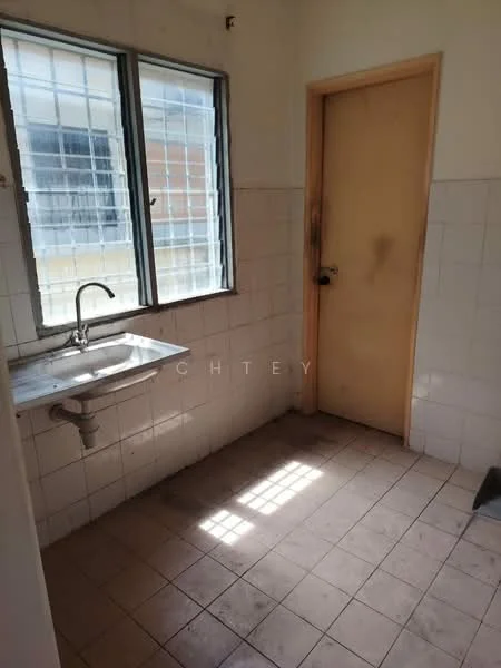 Room features: single-bowl stainless-steel sink, chrome faucet, white tiled walls, light brown tiled flooring, window with metal grille, wooden door, natural light from window.