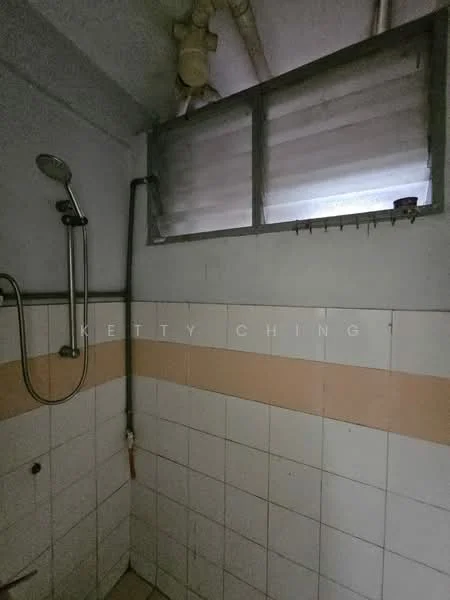 Bathroom features: shower with handheld showerhead, tile cladding on walls, white and beige tiled walls, window with horizontal slats, exposed plumbing, light fixture, drain on floor.