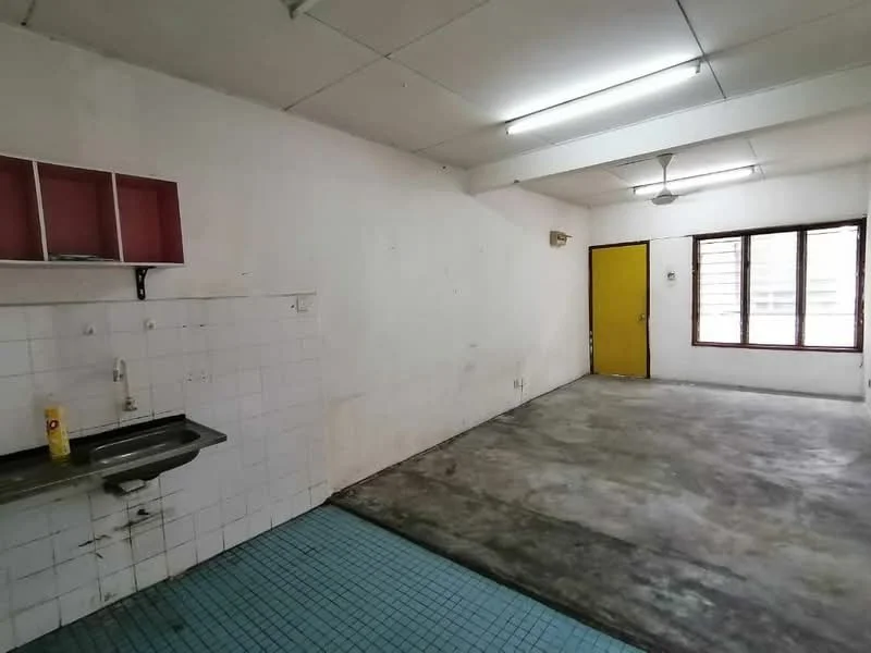 Room features: white painted walls, concrete flooring, blue square tile flooring, single-bowl stainless-steel sink, wall-mounted shelf with red cabinets, yellow door, two windows with metal grilles, ceiling fan, fluorescent lighting; style: minimalist.