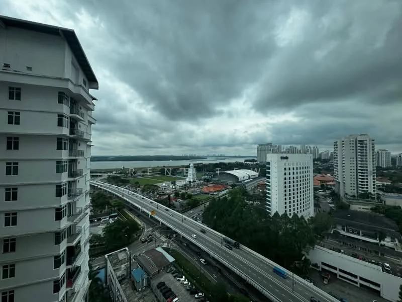 Exterior type: high-rise condominium; features: white painted facade, approximately 10-storey high-rise, surrounded by urban landscape, view of city skyline, near highway, cloudy sky; style: modern.