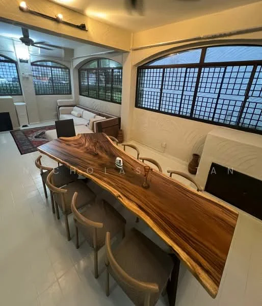 Dining features: large wooden dining table with live edge, 8 dining chairs with woven seats, white tiled flooring, ceiling fan with light, large windows with black metal grilles, sofa seating area in background, decorative area rug, wall-mounted light fixture; style: modern.