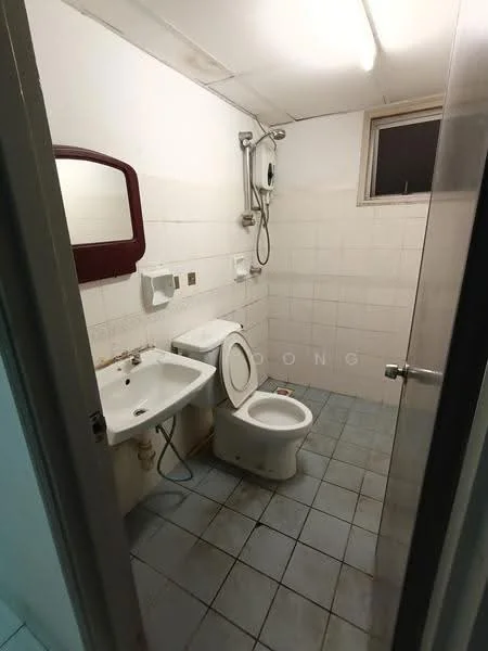 Bathroom features: white tiled walls, grey tiled flooring, single-sink vanity, mirror above sink, toilet, shower with handheld showerhead, wall-mounted soap dispenser, toilet paper holder, window for natural light, flush-mounted ceiling light.