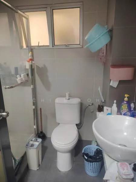 Bathroom features: one-piece toilet, glass shower enclosure, round vessel sink, chrome faucet, grey tiled walls, grey tiled flooring, window for natural light, wall-mounted soap dispenser, toiletries storage, basket for laundry, towel holder, shower caddy; style: modern.