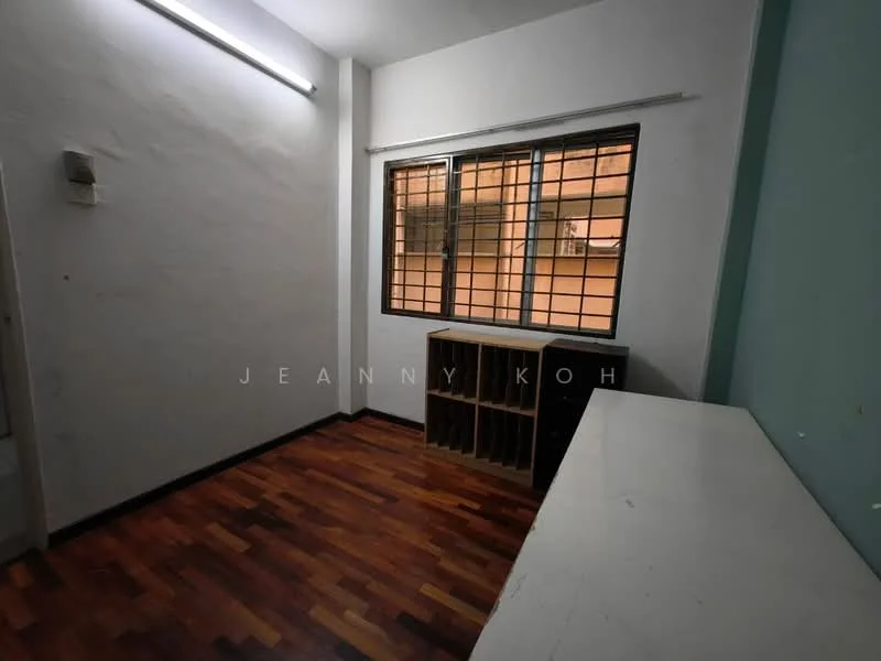 Room features: white painted walls, wooden flooring, large window with metal grille, built-in shelving unit, open space, neutral color scheme, ceiling light fixture, corner space; style: minimalist.
