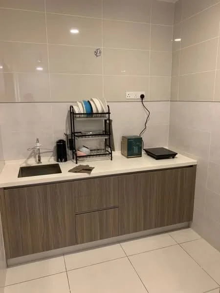 Kitchen features: single-bowl stainless-steel sink, chrome faucet, laminate cabinetry in wood finish, white countertop, ceramic tile backsplash, white tiled walls, grey tiled flooring, dish rack with plates, kettle, electric griddle; style: modern.