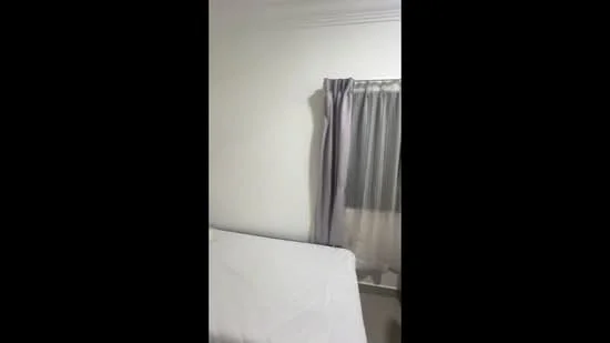 Room features: white painted walls, curtains in grey, window with sheer treatment, bed with white bedding.