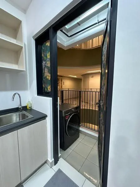 Laundry features: single-bowl stainless-steel sink, black countertop, light wood cabinetry, front-load washing machine, grey tile flooring, glass door, view of indoor balcony, safety railing; style: modern.