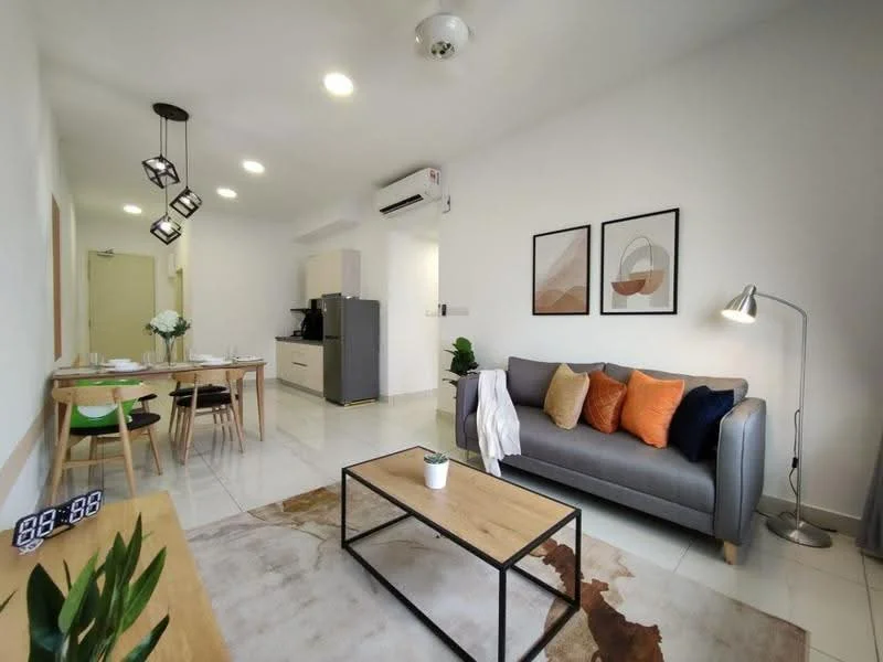 Living features: grey fabric sofa, orange and green decorative cushions, wooden coffee table, area rug with abstract pattern, floor lamp, wall-mounted TV, white painted walls, recessed downlights, sliding glass door, window with sheer curtains, dining table with 4 chairs, kitchenette visible in background, air conditioning unit; style: modern.