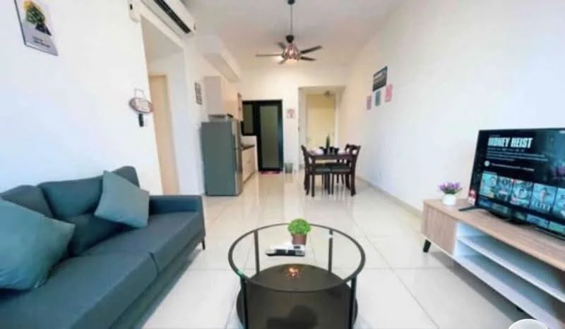 Living features: 3-seater fabric sofa in grey, glass coffee table, wall-mounted TV, TV console in light wood, white painted walls, tile flooring, ceiling fan with light, decorative plant on coffee table, dining table with 4 chairs in background, open layout to kitchen, air conditioning unit; style: modern. Kitchen features: kitchen cabinetry in light wood, stainless-steel fridge, countertop with space for appliances, tile flooring; style: modern.