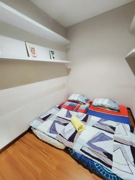 Bedroom features: wooden flooring, light grey painted walls, built-in shelves, bedding with geometric pattern, two pillows, yellow towel, blanket with geometric pattern; style: minimalist.