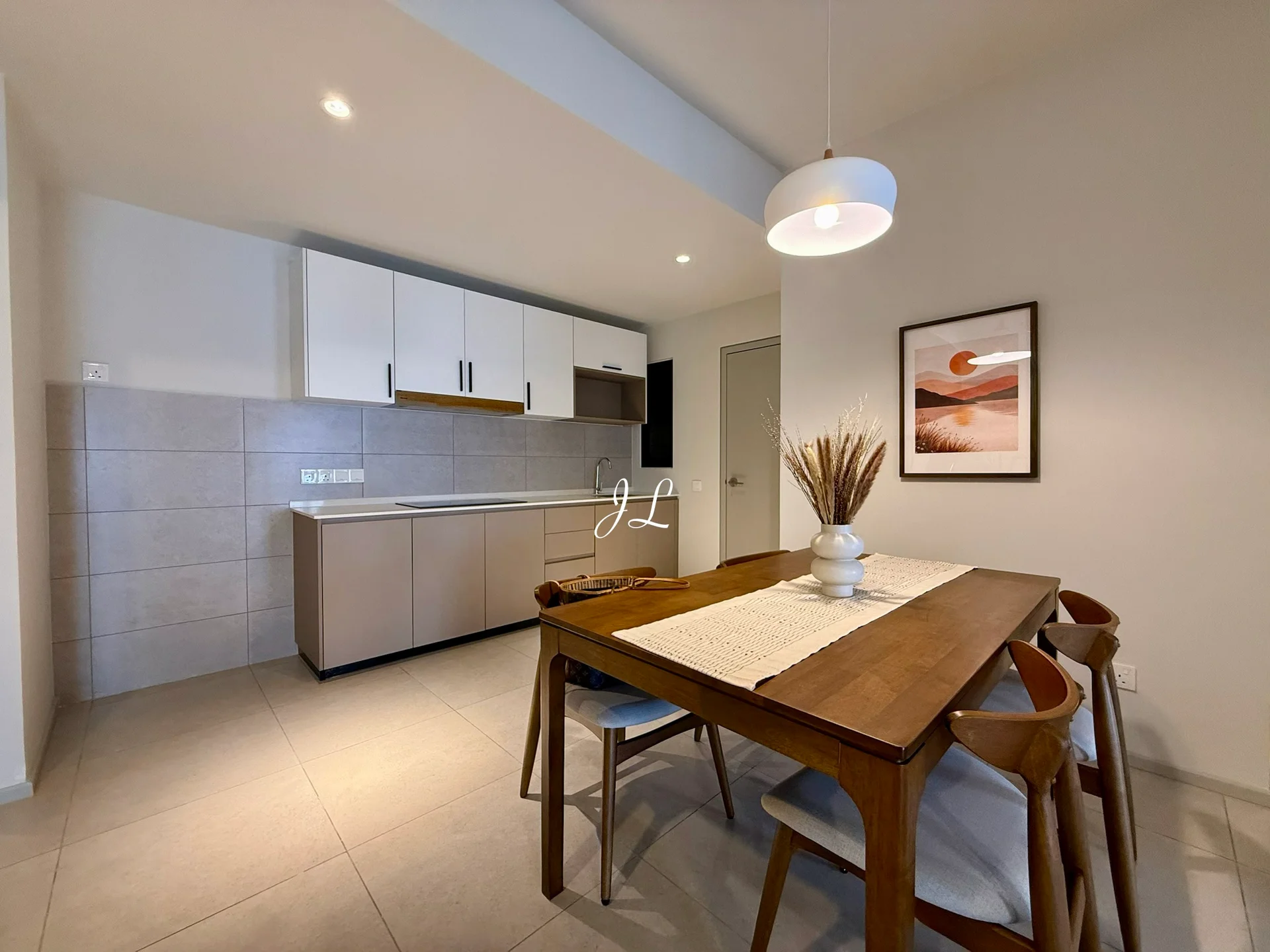 Dining features: wooden dining table, upholstered dining chairs, pendant light, framed artwork on wall, neutral wall colour, tile flooring, decorative vase with dried plants; style: modern. Kitchen features: white upper cabinets, grey lower cabinets, stainless-steel sink, single-bowl stainless-steel sink, chrome pull-down faucet, countertop with backsplash, built-in oven, ceramic tile flooring; style: modern.