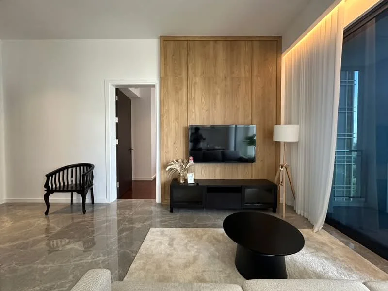 Living features: grey marble flooring, white painted walls, wood feature wall, wall-mounted TV, black TV console, black round coffee table, beige area rug, floor-to-ceiling windows with sheer curtains, decorative plant, standing lamp, black wooden chair; style: modern.