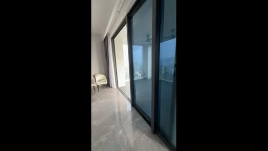 Room features: large sliding glass doors, marble flooring, neutral wall color, ceiling with recessed lighting, view of the city skyline, two chairs, curtains, open space layout; style: modern; view: city.