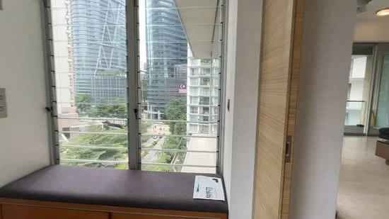 Room features: large windows, city view, window seat with cushion, wood cabinetry, neutral wall color, modern design, natural light, glass railing; style: modern; view: city.