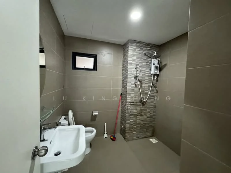 Bathroom features: grey tiled walls, light grey tiled flooring, walk-in shower with glass enclosure, rain shower head, handheld shower, toilet, single-sink vanity with wall-mounted faucet, mirror above sink, shower water heater, small window, towel rack, cleaning supplies visible; style: modern.