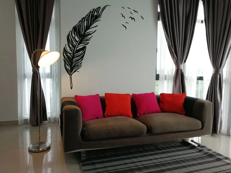 Living features: 3-seater fabric sofa in brown, decorative cushions in pink and orange, floor lamp with curved arm, grey area rug with stripes, white painted walls, floor-to-ceiling windows, sheer curtains in grey, dark grey curtains, wall decal of a feather, birds silhouette on wall, polished tile flooring; style: modern; view: city.