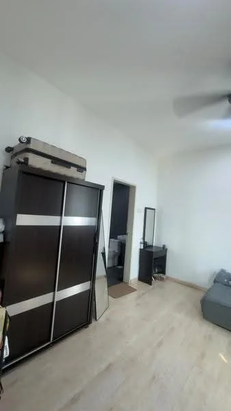Room features: white painted walls, wooden flooring, 5-blade ceiling fan, built-in wardrobe with sliding doors, full-length mirror, small side table, grey sofa, doorway leading to bathroom, luggage on top of wardrobe; style: modern.