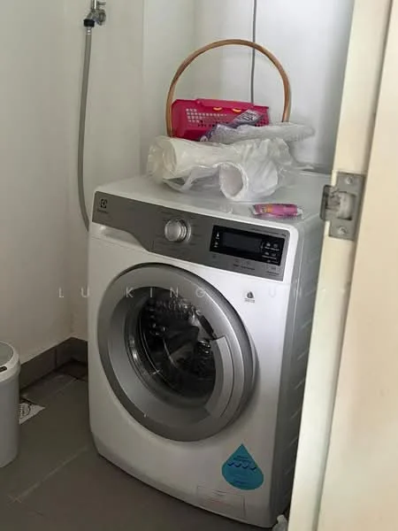Laundry features: front-load washing machine in white, grey tiled flooring, wall-mounted water supply, plastic laundry basket, plastic storage container, white waste bin.