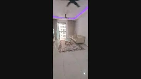 Living features: white painted walls, glossy tile flooring, 5-blade ceiling fan with light, sofa in cream color, coffee table, area rug with geometric pattern, floor-to-ceiling windows, curtains, recessed LED lighting with purple accent, balcony door; style: modern; view: city.