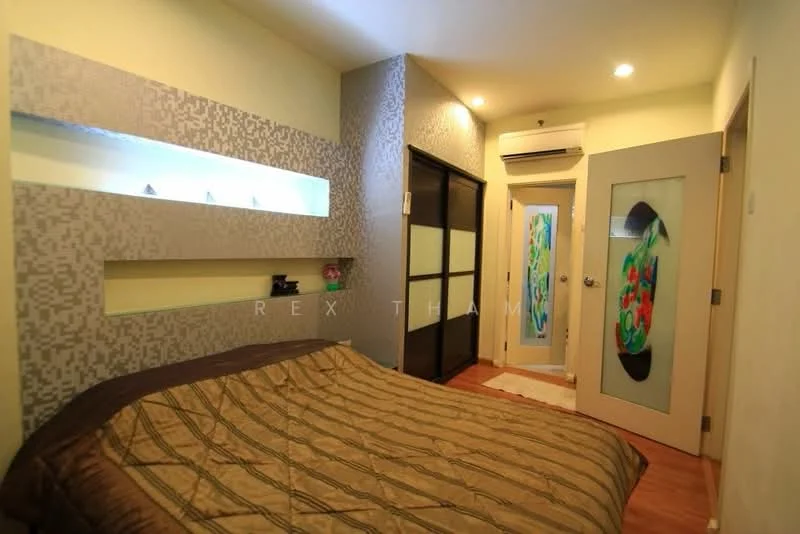 Bedroom features: queen-size bed with patterned bedding, decorative wall panel with backlighting, wooden flooring, built-in wardrobe with sliding doors, wall-mounted air conditioning unit, door with decorative glass panel, light fixtures in ceiling, neutral wall color; style: modern.