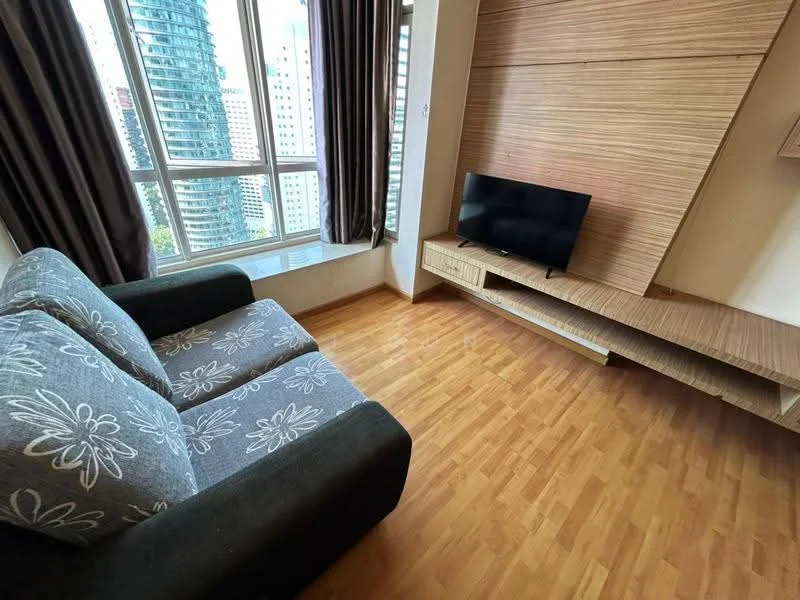 Living features: 3-seater fabric sofa in grey with floral pattern, wooden flooring, wall-mounted TV, TV console with storage, large windows with city view, curtains, wood panel accent wall, natural light; style: modern; view: city.