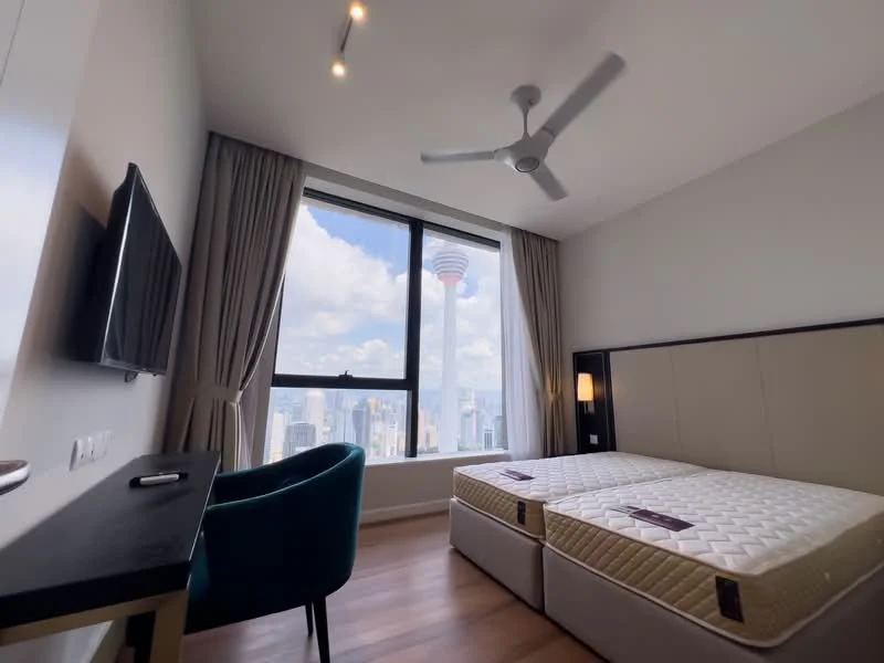 Bedroom features: king-size bed, upholstered headboard, wooden flooring, floor-to-ceiling window, city view, 5-blade ceiling fan with light, wall-mounted TV, black desk, blue accent chair, curtains, decorative lighting; style: modern; view: city.